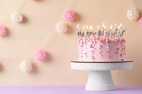 Birthday cake with burning candles on violet table, space for text Stock Photos
