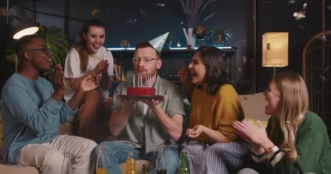 BIRTHDAY CAKE Happy smiling red haired man blows on cake at fun confetti party 스톡 동영상 169521953