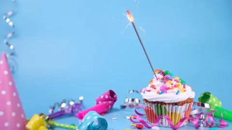 Birthday cake or cupcake with a burning sparkler on a blue background. Party Stock Footage 196855075