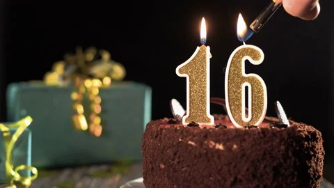 Birthday candle number sixteen on a sweet cake on the table, 16th birthday. Fire Stock Footage