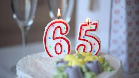 Birthday candle as number sixty five 65 on top of sweet cake on the table Stock Footage 150253264