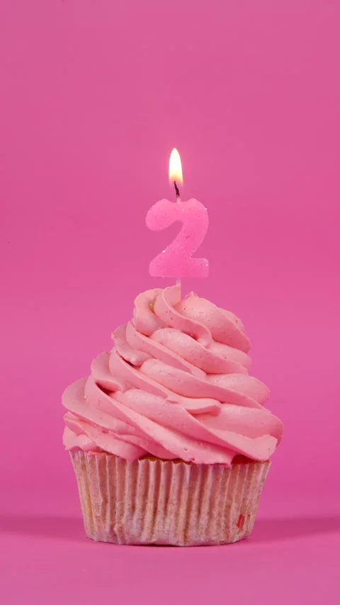 Birthday cupcake with burning candle from zero to nine on a pink background Stock Footage 274671918