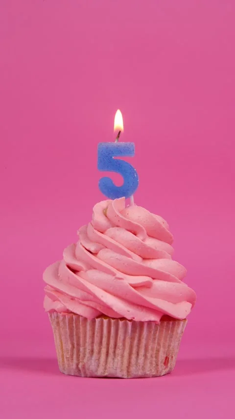 Birthday cupcake with number five candle on a pink background. Holiday concept Stock Footage 274504339