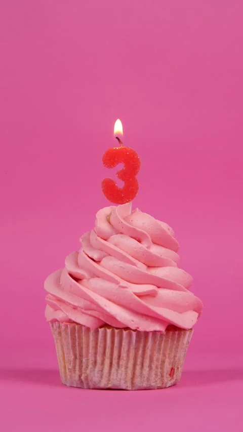 Birthday cupcake with number three candle on a pink background. Holiday concept Stock Footage 274735564