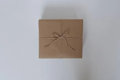 Birthday present in craft wrapper on white background in the middle Stock Photos