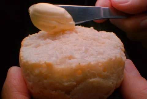 A biscuit being spread with butter, close-up Stock Footage 86883801