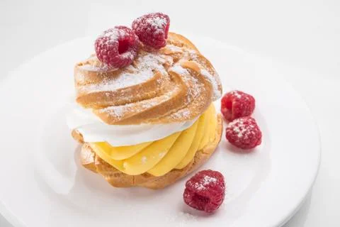 Biscuit cake with raspberry berries on a white plate. On white table. Stock Photos