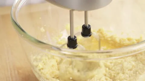 Biscuit dough being mixed with a hand mixer and eggs being added 스톡 동영상 24656452