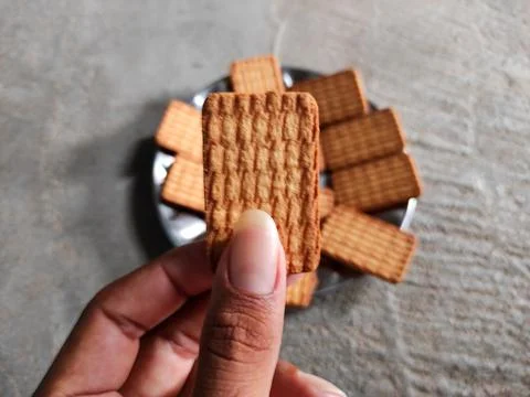 Biscuit held in hand Stock Photos