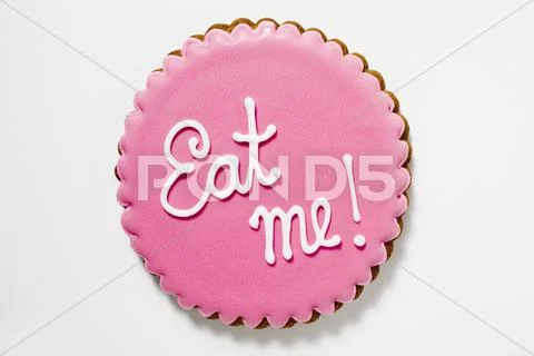 Biscuit with pink icing and the words 'Eat me!' Stock Photos