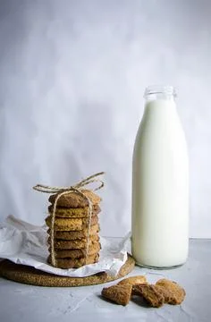 Biscuits and milk on a gray background. Stock Photos