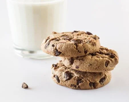 Biscuits with chocolate chips inside and a glass of milk. Stock Photos