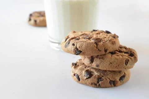 Biscuits with chocolate chips inside and a glass of milk. Stock Photos