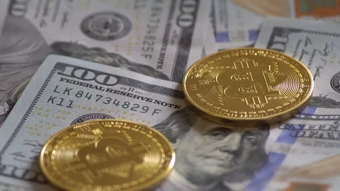 Bit Coin BTC coins rotating on bills of dollars. Virtual cryptocurrency. Stock Footage 88657343