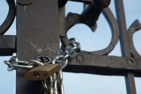 Bit coin on old gate with lock and chain Stock Photos