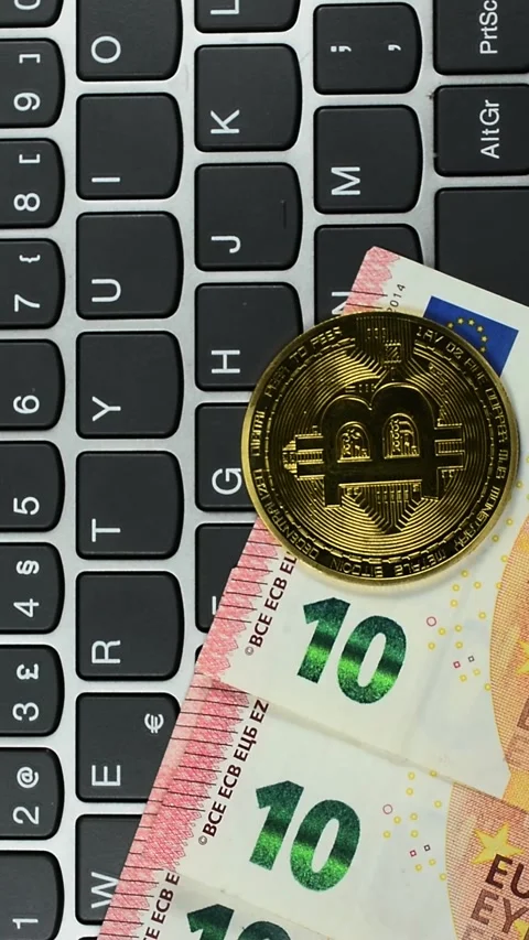 Bit Coins and Euro money on computer Keyboard vertical view Stock Footage 340389341