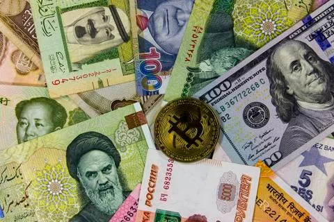 Bitcoin against  background of banknotes of different countries. Fotos de archivo