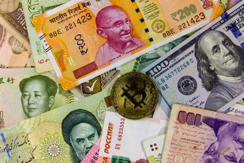 Bitcoin against  background of banknotes of different countries. Fotos de archivo
