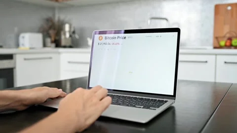 Bitcoin and cryptocurrency volatility. Young woman sits at laptop at home and Stockbeeldmateriaal 219608951