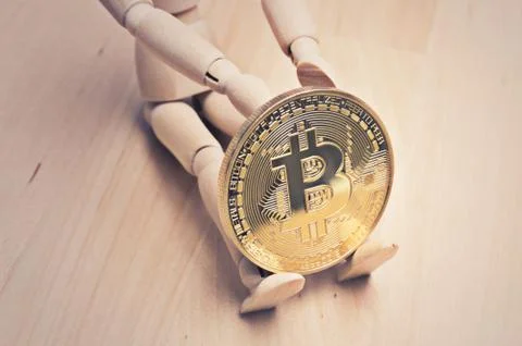 Bitcoin and doll on table Stock Photos