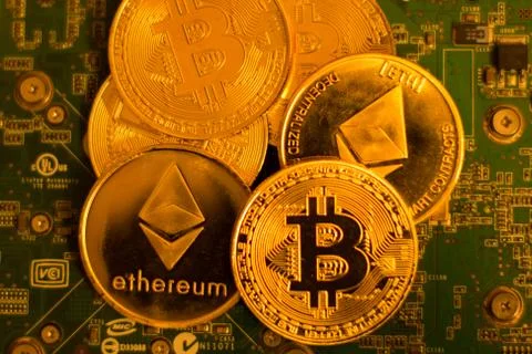 Bitcoin and Etherium on a circuit board Stock Photos