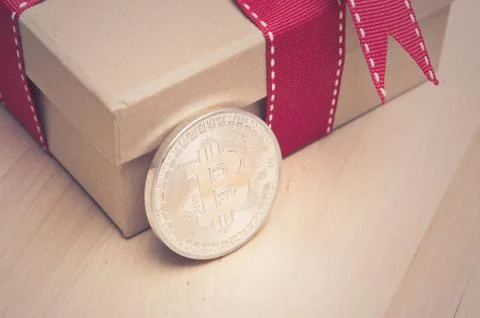 Bitcoin and gift box with red ribbon Stock Photos