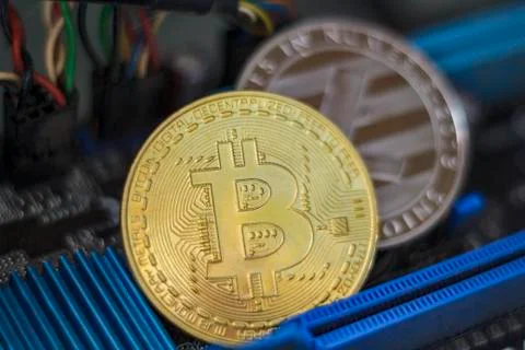 Bitcoin and Litecoin on electronic computer processor board. Virtual/digital  Stock Photos