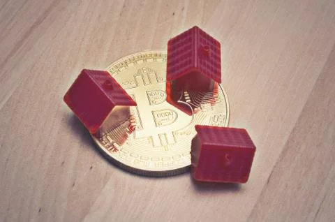 Bitcoin and mini red house on table Stock Photos