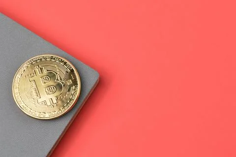 Bitcoin and notebook over red background with copy space. Stock Photos