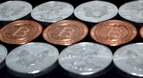 Bitcoin and Silver Bullion Coins, Crypto coin price volatility, Closeup Stock Photos