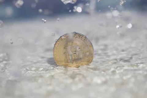 Bitcoin being splashed with water Stock Photos