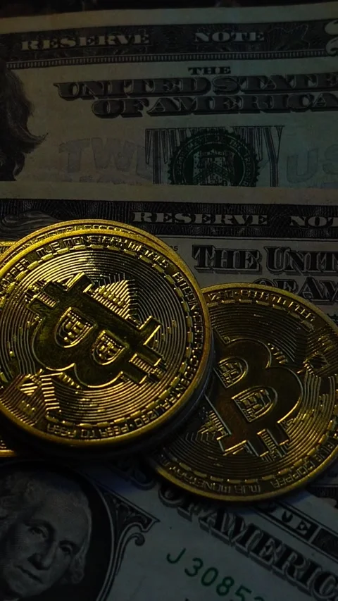 Bitcoin BTC coin with 100 dollars bills. Investments for the investor Stock Footage 327728345