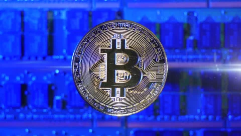 A Bitcoin BTC crypto currency coin hovering over a mining rig of computer Stock Footage 160949855