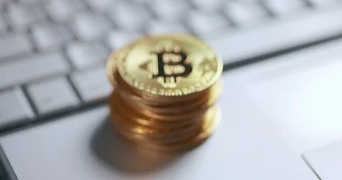 Bitcoin BTC cryptocurrency. Stack of golden coins on laptop keyboard. Defocused Stock Footage 149077955