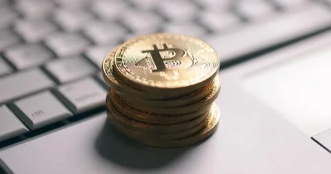 Bitcoin BTC cryptocurrency. Stack of golden coins on laptop keyboard Stock Footage 149077977