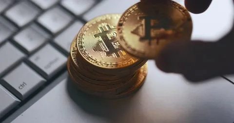 Bitcoin BTC cryptocurrency. Stack of golden coins on laptop keyboard. Hand puts Stock Footage 149267941