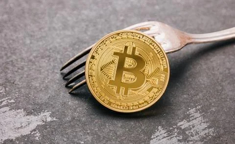 Bitcoin (BTC) on a Fork, digital cryptocurrency concept image Stock Photos
