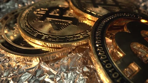 Bitcoin BTC many cryptocoins on the table in gold light rotate. Macro shot Stock Footage 129614681