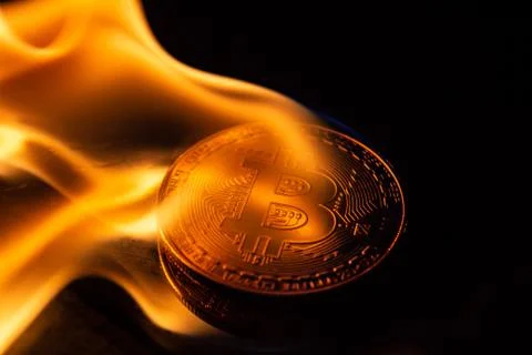 Bitcoin burning in fire on black background Stock Photos