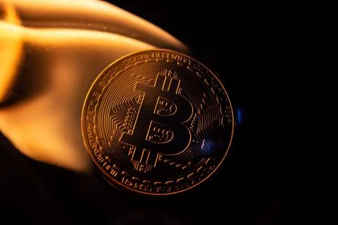 Bitcoin burning in fire on black background Stock Photos