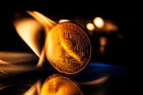 Bitcoin burning in fire on black background Stock Photos