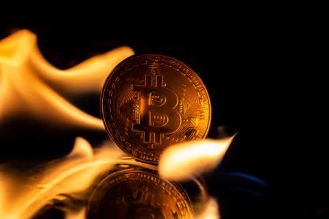 Bitcoin burning in fire on black background Stock Photos