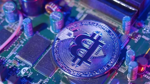 Bitcoin on circuit board spinning. Cryptocurrency bit-coins and computer main Stock Footage 153620567