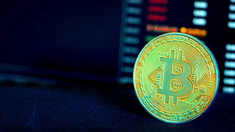 Bitcoin Coin Against the Background of a Cryptocurrency Chart Stock Footage 260823613
