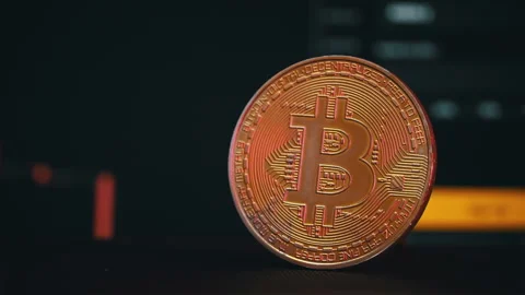 Bitcoin Coin Against the Background of a Cryptocurrency Chart Stock Footage 260942068