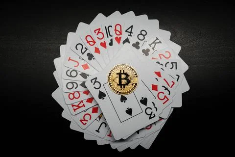 Bitcoin coin on a deck of playing cards. Bitcoin casino game. Stock Photos