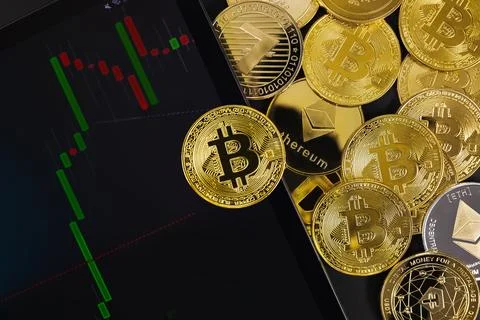 Bitcoin coin on digital tablet with graph by various coins Stock Photos