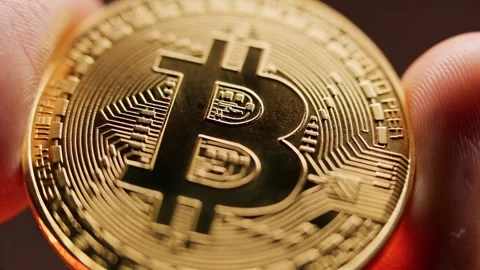 Bitcoin coin held between someone's fingers. Stock Footage 297843797