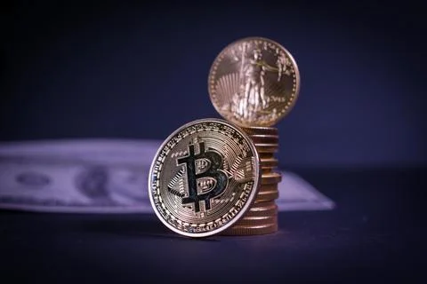 Bitcoin coin leans on a stack of other gold coins Stock Photos