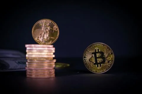 Bitcoin coin stands next to a stack of other gold coins Stock Photos